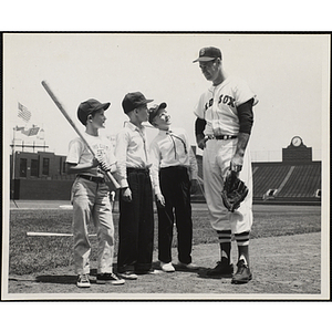 Boston Red Sox Ted Williams posing with three Boys' Club members at Fenway Park, Boston, Mass