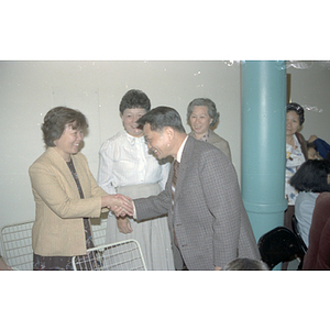 Member of the Consulate General of the People's Republic of China shakes hands with a few women at a welcome party held for the Consulate General's visit to Boston