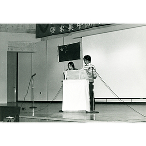 Two men at the podium in the Josiah Quincy School auditorium at an event about the normalization of U.S. and China relations