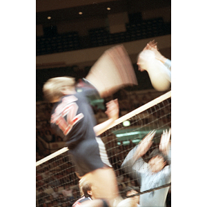 United States Men's Volleyball Team member hits the ball over the net to score against the Chinese Men's Volleyball Team