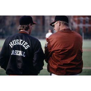 Men's baseball player speaking with coach