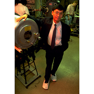 Chung Chan, a former assistant professor in electrical and computer engineering, standing beside machinery in a laboratory