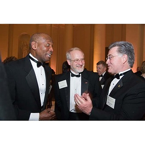 Dean Stellar converses with two other men at the inauguration celebration of President Aoun