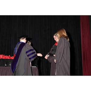 Faculty member presents students with gift bags at School of Nursing convocation