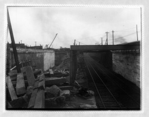 View of railroad tracks under a bridge, probably Dorchester Ave. bridge