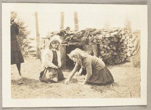 Untitled: two girls near a woodpile, presumably on the Lyman Estate in Waltham, Mass.