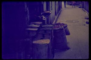 Bags of peppers and produce stashed in an alley
