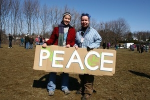Two women holding a sign reading 'Peace': rally and march against the Iraq War