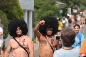 Two men in Afro wigs and raised fist painted on their chests : Provincetown Carnival parade