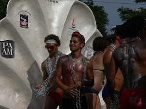Parade marchers with strings of beads around their neck and giant clamshell : Provincetown Carnival parade