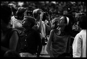 Beatles concert at Shea Stadium: Beatles fans, including young boy and girl looking up and three older fans with binoculars