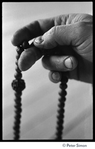 Hand holding a string mala beads for meditation, Rowe Center spiritual retreat