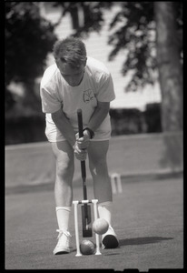 Croquet player hitting a ball through the wicket, Newport, R.I.