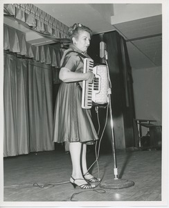 Unidentified woman playing accordian at Thanksgiving celebration