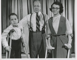 Unidentified man posing with a young woman and boy with cerebral palsy