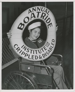 Woman in wheelchair poses with sign