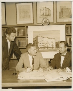 Willis C. Gorthy signing paperwork at a presentation of prospective building plans