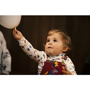 Young child touching a balloon