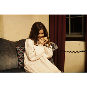 Girl wearing a nightdress using a telephone