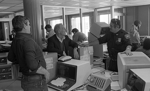 Mayor Kevin White, unidentified men and police officer smiling in Boston Police Dispatch Operations Center