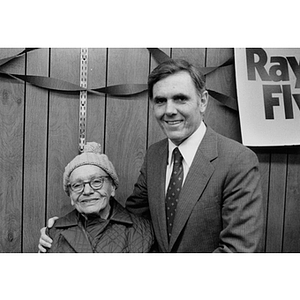 Mayor Raymond Flynn stands with his arm around an elderly woman at an event