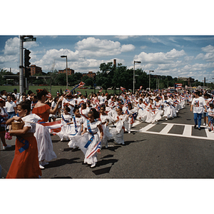 Young girls in white dresses walk in the Festival Puertorriqueño parade