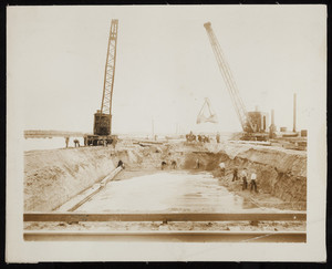 Steam shovels and men with shovels at work on construction of the Cape Cod Canal.