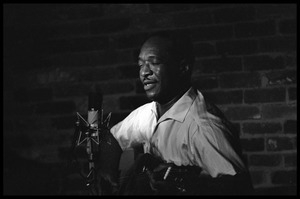 Josh White performing on guitar in a coffeehouse