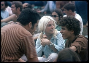 Concert goers sitting on the grass at the Woodstock Festival