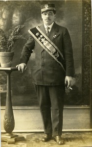 Member of "Jolly Get Together" (Southampton, Mass.), wearing regalia of St. Stanislaw Kostka Brotherhood: full length studio portrait with hand on plant stand