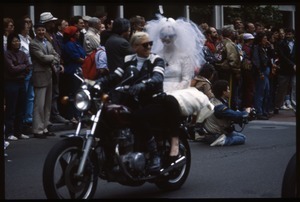 Two motorcyclists, one wearing a wedding dress and bridal veil, in the San Francisco Pride Parade