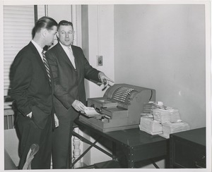 Two men looking at a cash register during an administrators' training event