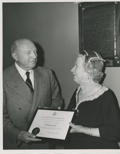 Unidentified man handing Colonel Smith's citation for distinguished service to an unidentified woman