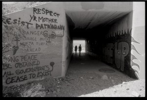 Graffiti ('Respect your mother, resist patriarchy') on concrete underpass at Nevada Test Site peace encampment