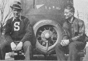 Unidentified men sitting on car bumper