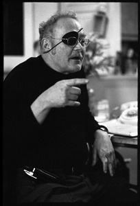 W. Eugene Smith, seated at a desk in his home