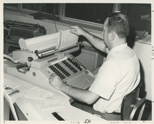 A man uses a large adding machine at TOWER training