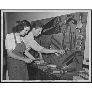 Young man and woman working with carpentry tools