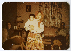 Person in traditional Portuguese clothes, holding baby