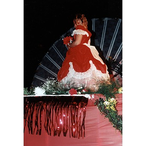 Girl in a full red dress standing among the flowers on the stage at the 1998 Festival Betances beauty contest.