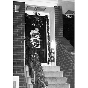Christmas decorations on the front door and front steps of a Villa Victoria house.