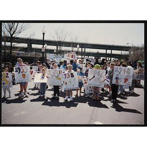 Several girls in the front row posing with their signs at the Boys and Girls Clubs of Boston 100th Anniversary Celebration Parade