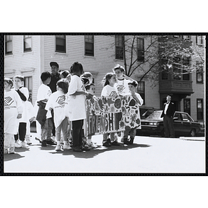 A group of boys and girl stand with a banner reading "FRIENDSHIP" during the Boys and Girls Clubs of Boston 100th Anniversary Celebration Parade