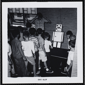 Boys wait to play an indoor ball toss game at a carnival