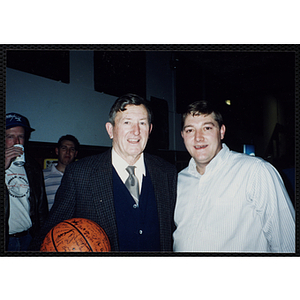 Two Bunker Hillbilly alumni pose with an autographed basketball at a reunion event