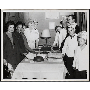 Members of the Tom Pappas Chefs' Club and adults, including Chef's Club committee member Mary A. Sciacca (4th from left), pose around a table of baked goods