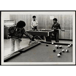 A group of boys play pool