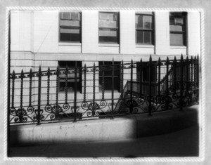Wrought-iron fence in front of stone building