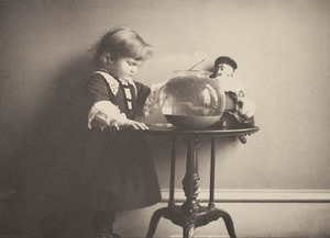 Small child with fishbowl on table
