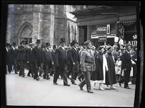 James Michael Curley (in top hat, staring at camera) and procession marching past Cathedral of the Holy Cross
